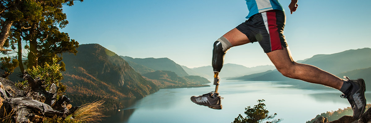 Man with artificial leg jogging out in nature