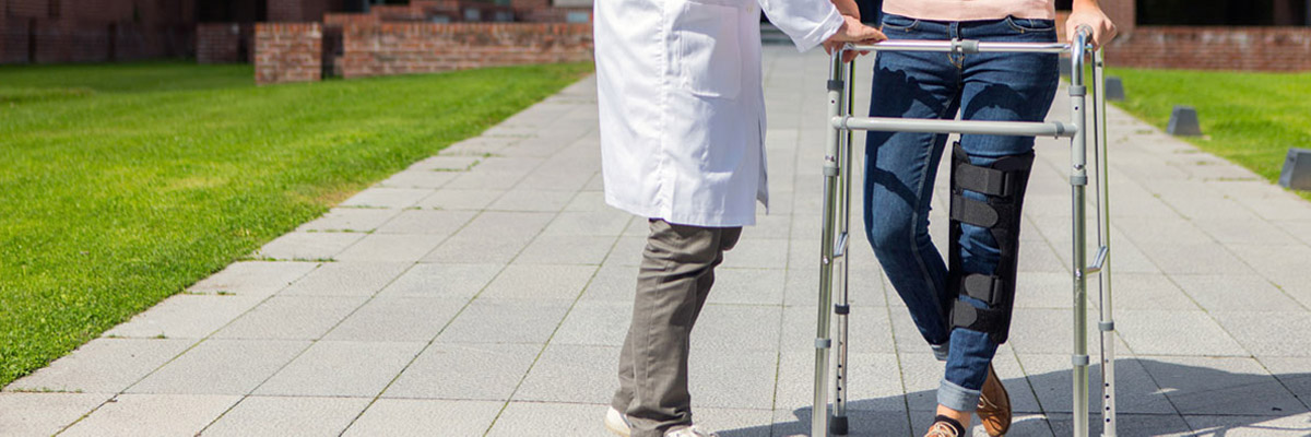 Doctor helps patient in a walker