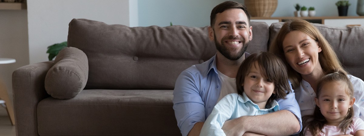 Family smiling in their living room